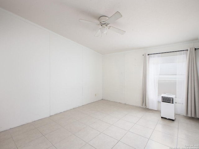 empty room with light tile patterned floors and a ceiling fan