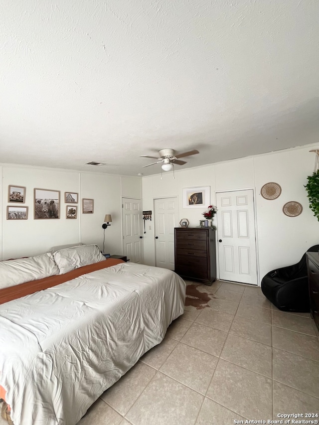 tiled bedroom featuring ceiling fan