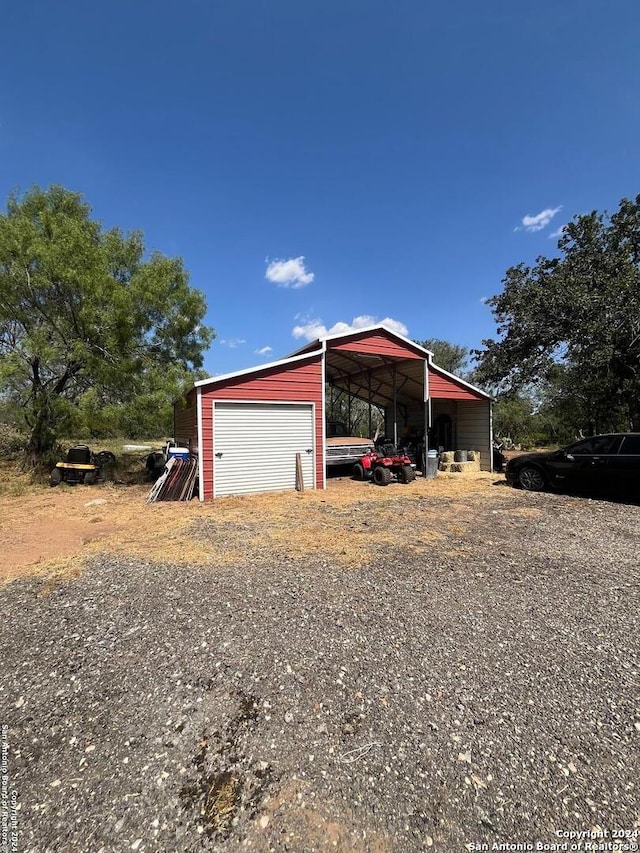 exterior space featuring a garage, an outdoor structure, and a carport