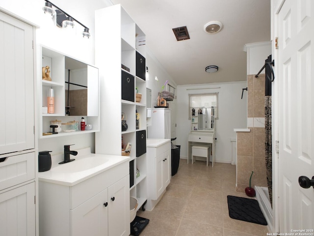 full bath with a sink, two vanities, tile patterned flooring, and a shower stall