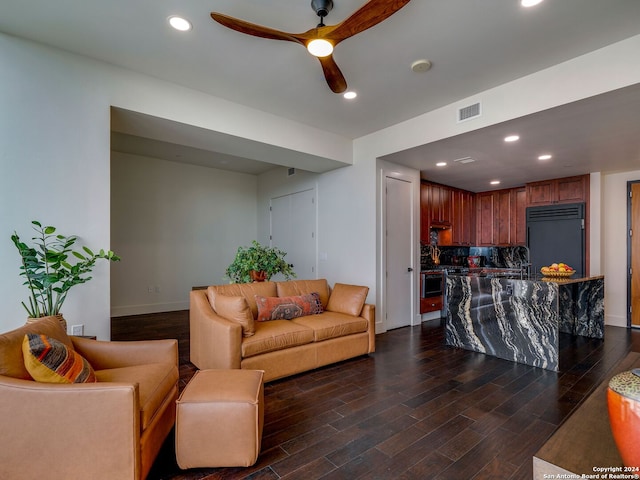 living room featuring ceiling fan and dark hardwood / wood-style flooring