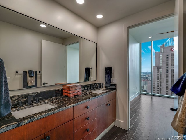 bathroom with vanity, hardwood / wood-style flooring, expansive windows, and a shower