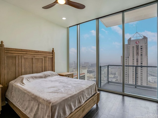 bedroom featuring hardwood / wood-style flooring, ceiling fan, and multiple windows