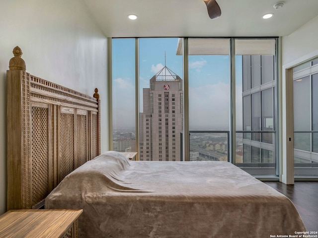 bedroom with dark hardwood / wood-style flooring, expansive windows, ceiling fan, and multiple windows