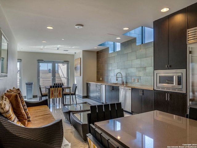 kitchen featuring appliances with stainless steel finishes, tasteful backsplash, and sink