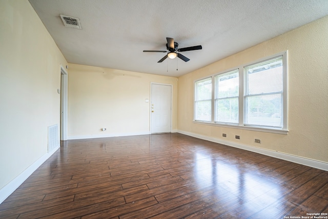 unfurnished room with a textured ceiling, ceiling fan, and dark hardwood / wood-style floors