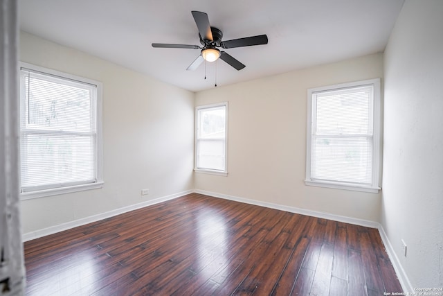 unfurnished room with dark hardwood / wood-style flooring, a healthy amount of sunlight, and ceiling fan