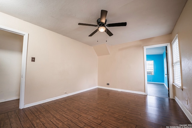 empty room with ceiling fan, dark hardwood / wood-style floors, and a textured ceiling