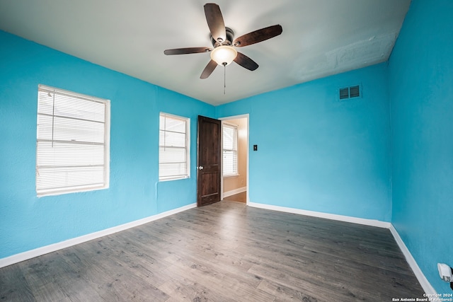 spare room with ceiling fan, dark hardwood / wood-style flooring, and a healthy amount of sunlight