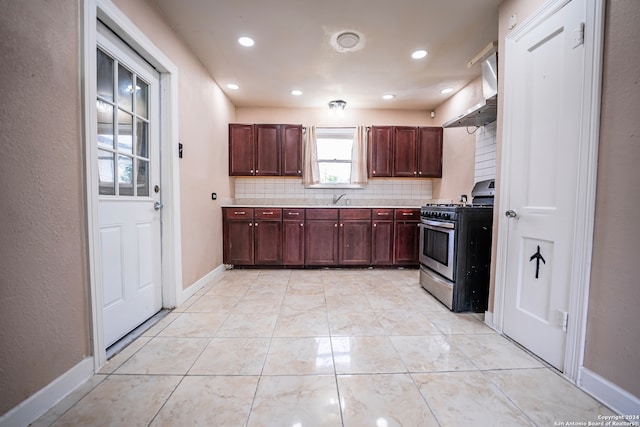 kitchen featuring wall chimney range hood, gas range, decorative backsplash, and sink