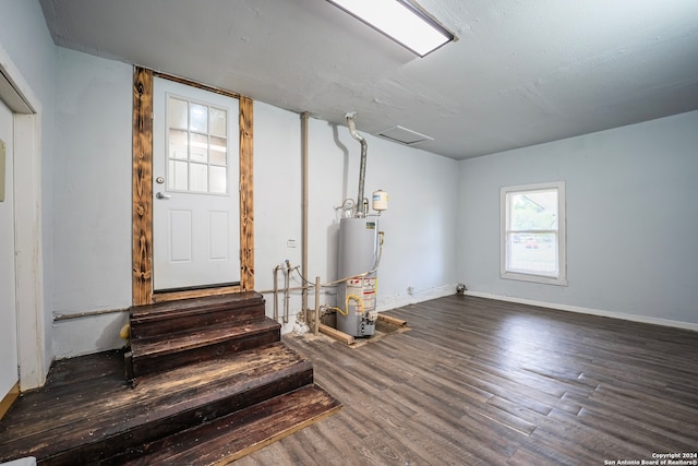 basement featuring gas water heater and wood-type flooring