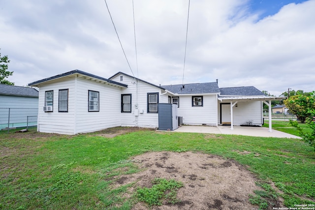 rear view of house with a yard, cooling unit, and a patio