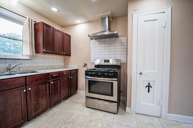 kitchen with island range hood, tasteful backsplash, stainless steel gas range oven, and sink