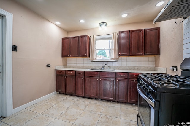 kitchen featuring black gas stove, light tile patterned floors, tasteful backsplash, and sink