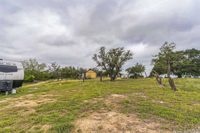 view of yard with a storage shed and a rural view