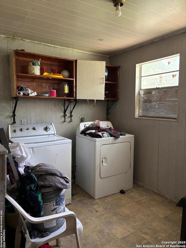 laundry area featuring wooden walls, laundry area, and washing machine and dryer
