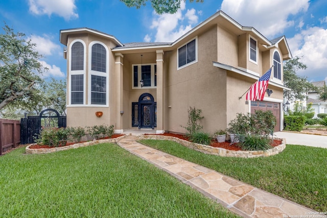 view of front of home with a garage, fence, concrete driveway, stucco siding, and a front lawn