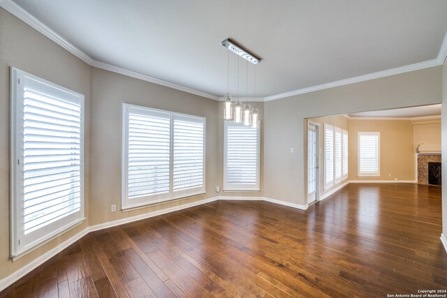 interior space with crown molding, a healthy amount of sunlight, dark hardwood / wood-style floors, and an inviting chandelier