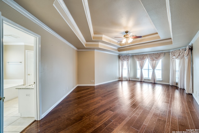 spare room featuring ornamental molding, hardwood / wood-style floors, a tray ceiling, and ceiling fan