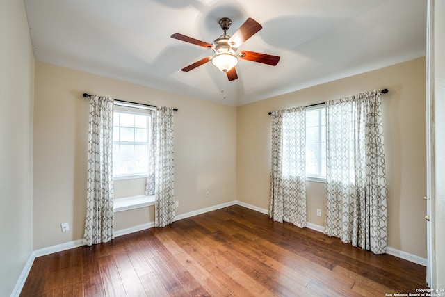 empty room with dark wood-type flooring and ceiling fan