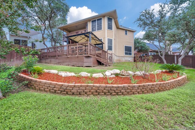 rear view of property featuring a lawn and a wooden deck