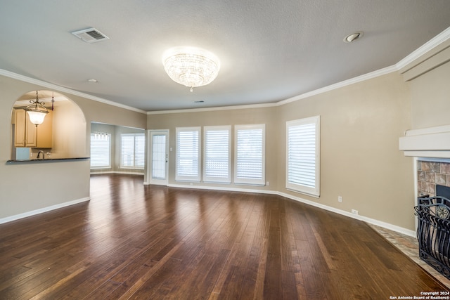 unfurnished living room with sink, dark hardwood / wood-style flooring, a chandelier, and ornamental molding