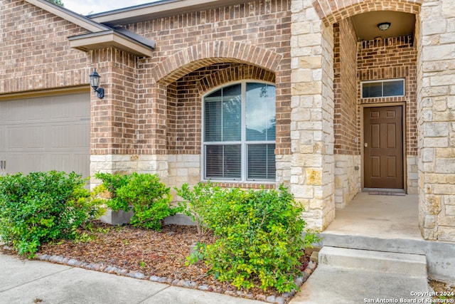 view of exterior entry with a garage