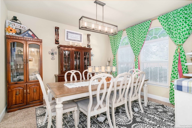 dining room featuring light colored carpet and an inviting chandelier