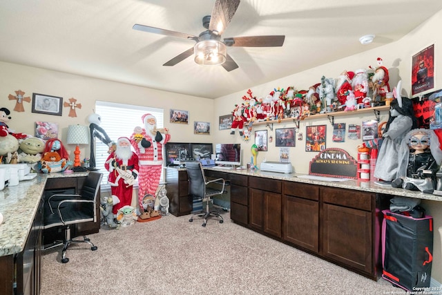 office area with built in desk, ceiling fan, and light carpet