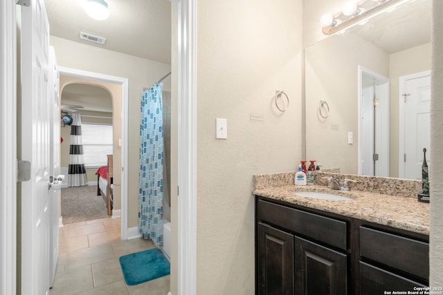 bathroom with tile patterned floors, shower / tub combo with curtain, a textured ceiling, and vanity