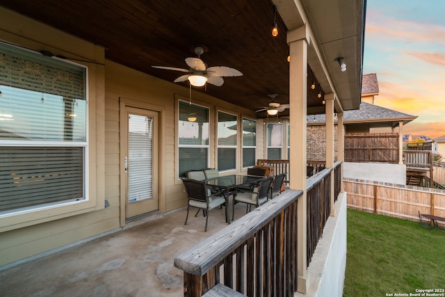 patio terrace at dusk with a lawn and ceiling fan