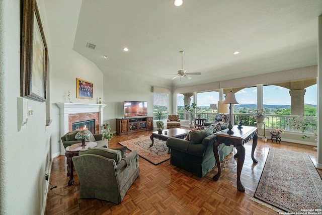 living room featuring dark parquet flooring, ceiling fan, a premium fireplace, and vaulted ceiling