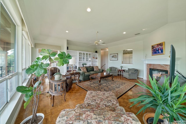 living room with ceiling fan, parquet flooring, and a fireplace