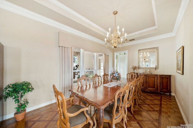 dining area with dark parquet flooring, a raised ceiling, an inviting chandelier, and crown molding