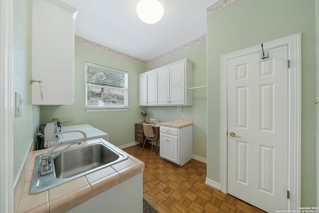 interior space with washer and clothes dryer, light parquet floors, cabinets, and sink