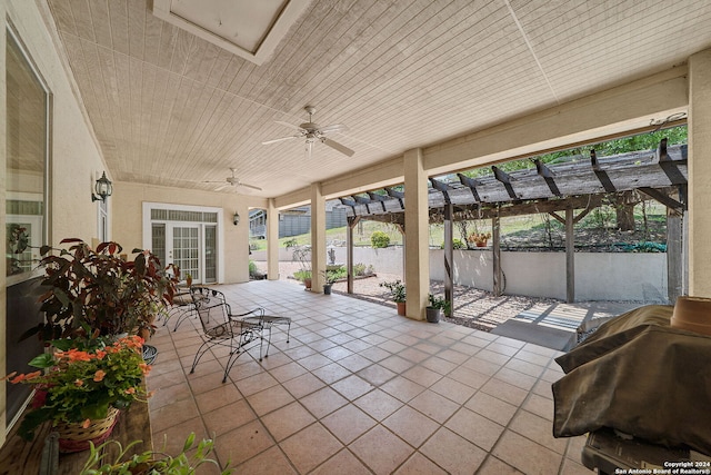 unfurnished sunroom with wooden ceiling, plenty of natural light, and ceiling fan