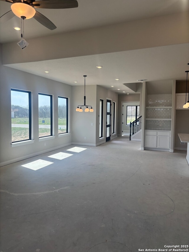 unfurnished living room featuring unfinished concrete floors, baseboards, ceiling fan, stairs, and recessed lighting