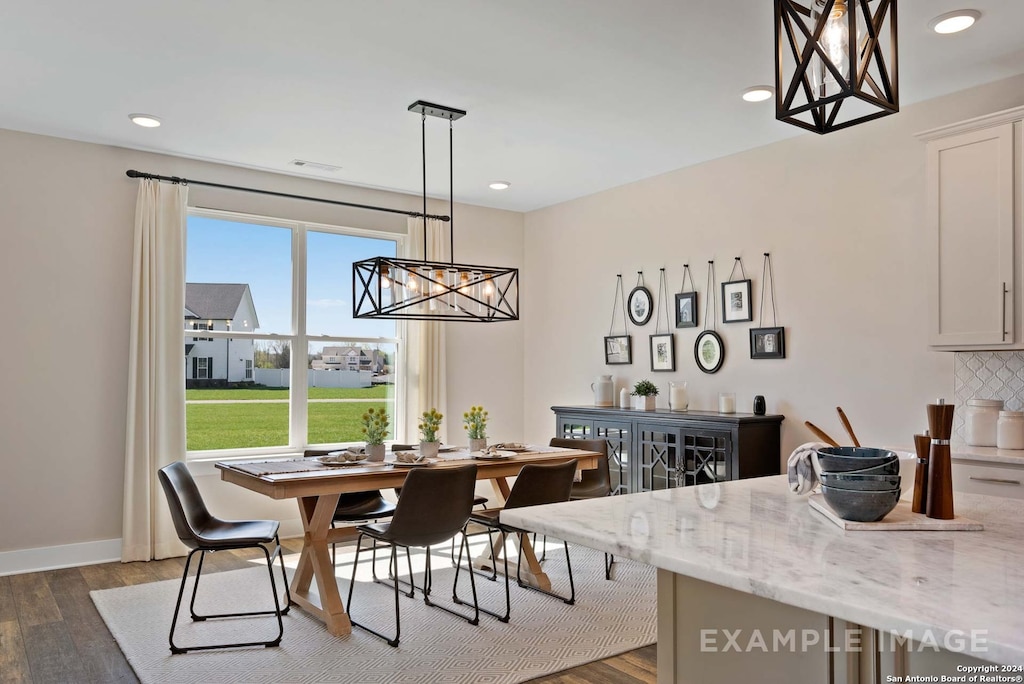 dining room with dark wood-type flooring and a chandelier