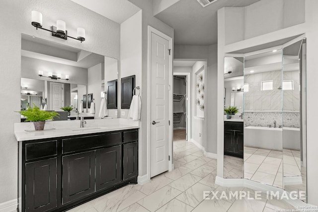 bathroom with independent shower and bath, a textured ceiling, and vanity