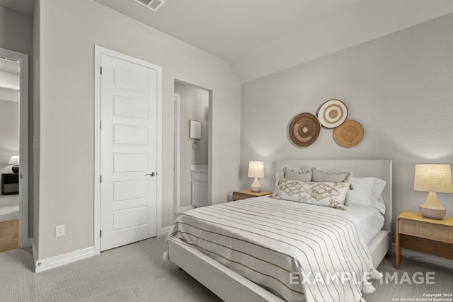 carpeted bedroom featuring vaulted ceiling and connected bathroom