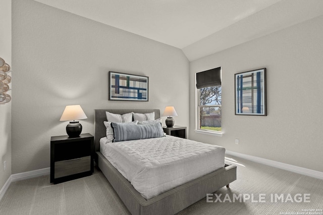 bedroom with lofted ceiling and light colored carpet