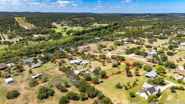 drone / aerial view featuring a wooded view