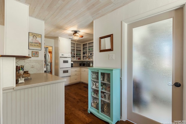 kitchen with stainless steel refrigerator, dark hardwood / wood-style flooring, ceiling fan, double oven, and decorative backsplash