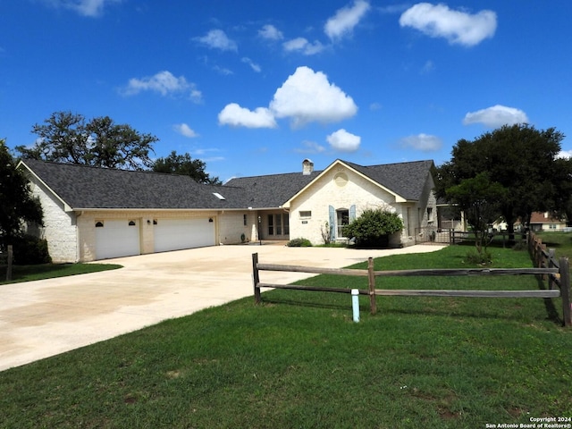 view of front facade featuring fence, a chimney, concrete driveway, a front lawn, and a garage