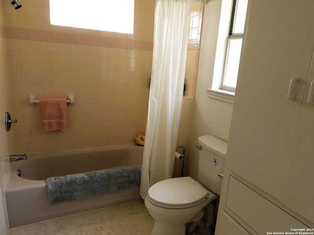 bathroom featuring shower / bath combination with curtain, toilet, and tile patterned flooring