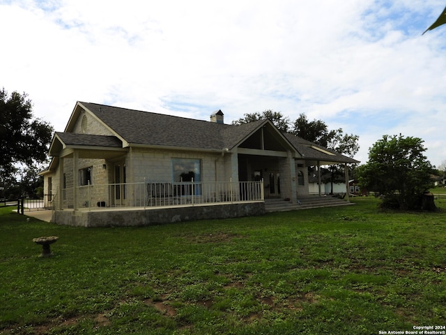 rear view of property with a yard and a porch