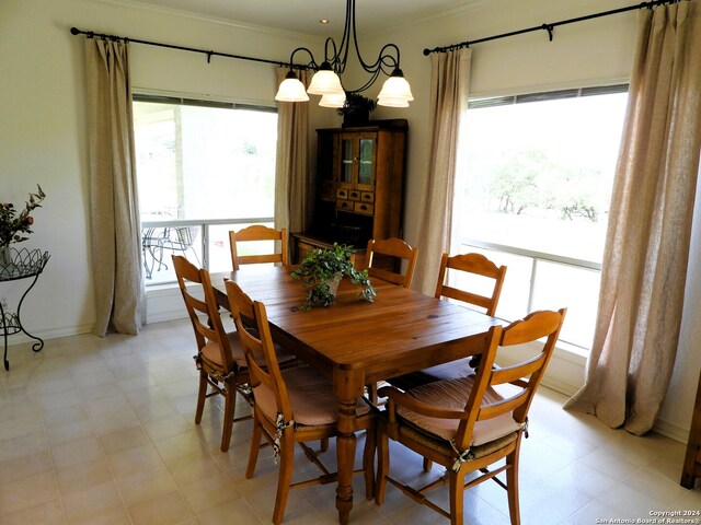 dining area with a wealth of natural light, an inviting chandelier, and ornamental molding