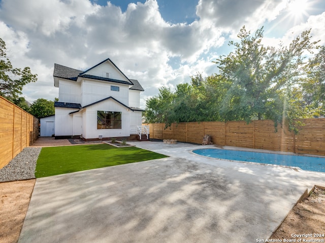 back of house with a covered pool and a patio area