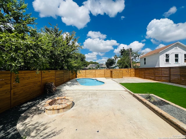 view of swimming pool featuring a fire pit and a patio