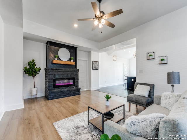 living room with ceiling fan, hardwood / wood-style flooring, and a fireplace